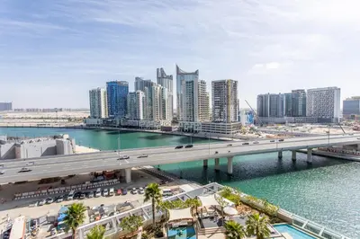 a city with a bridge over a body of water at The S Holiday Homes Canal view Studio and One Bedroom Apartments, Damac Maison Prive in Dubai