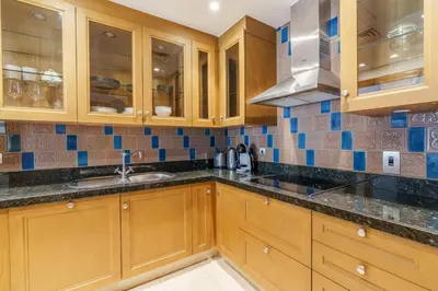 a kitchen with wooden cabinets and a sink at GuestReady - Luxe Arabian Apartment in Downtown in Dubai