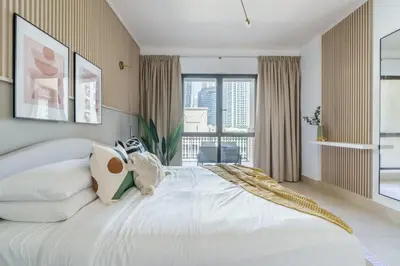 a bedroom with a large white bed with a window at GuestReady - Luxe Arabian Apartment in Downtown in Dubai
