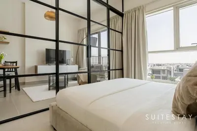 a bedroom with a large bed and a tv at Chic One Bedroom Suite with Cozy Interiors in Dubai