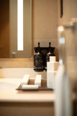 a reflection of two bottles of coffee in a mirror at Holiday Inn & Suites - Dubai Science Park by IHG in Dubai