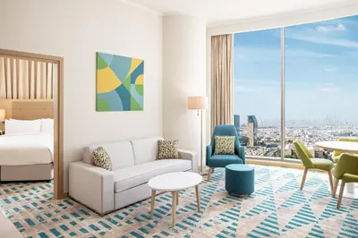 a hotel room with a bed and a couch and a table at Holiday Inn & Suites - Dubai Science Park by IHG in Dubai