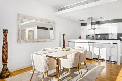 a dining room with a table and chairs and a mirror at Phenomenal 2BR with Scenic Sea-View from ALL rooms! in Dubai