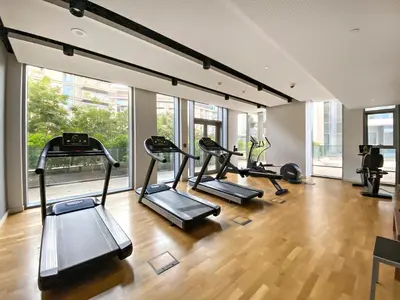 a gym with treadmills and ellipticals in a room with windows at Phenomenal 2BR with Scenic Sea-View from ALL rooms! in Dubai