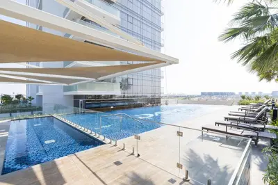 a swimming pool on the side of a building at Tranquil 1BR apartment in Carson C, Damac Hills - Allsopp&Allsopp in Dubai