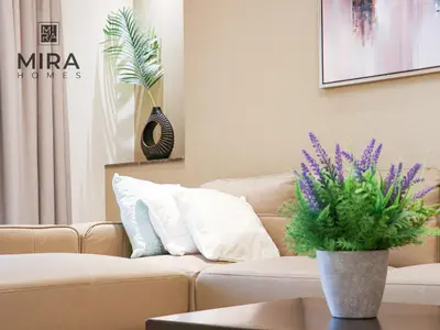 a living room with a couch and a vase with purple flowers at Mira Holiday Homes - Lovely 1 bedroom in Downtown in Dubai