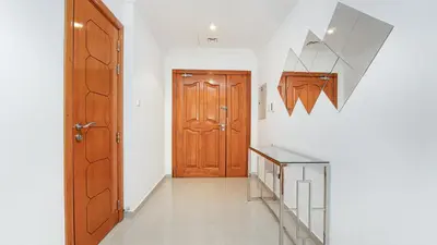 a hallway with a wooden door and a staircase at Cosy 1 Bedroom Marina Apartment in Dubai