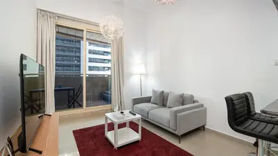 a living room with a couch and a chair at Cosy 1 Bedroom Marina Apartment in Dubai