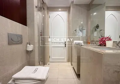 a bathroom with a white toilet and a sink at Upgraded 1BR in Downtown with Burj Khalifa View in Dubai