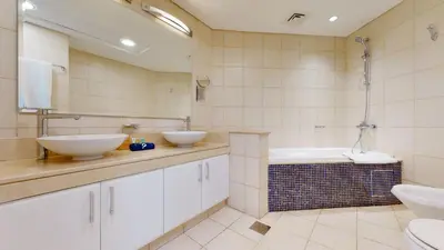 a bathroom with two sinks and a bath tub at Elegant 2 BR Apartment with Beach Access in Dubai
