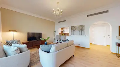 a living room with two couches and a television at Elegant 2 BR Apartment with Beach Access in Dubai