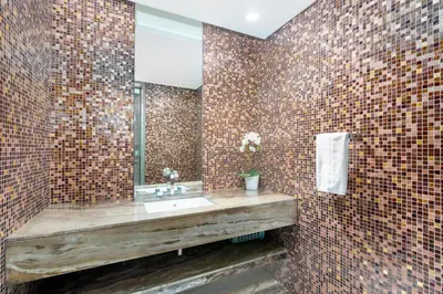 a bathroom with a sink and a mirror on a brick wall at White Sage - Fendi Apartment With Full Palm Jumeirah View in Dubai