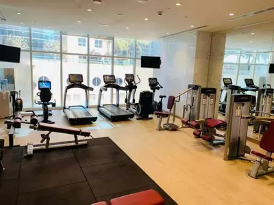a gym with several treadmills and machines in a room at White Sage - Fendi Apartment With Full Palm Jumeirah View in Dubai