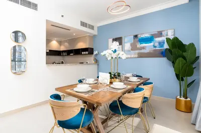 a dining room with a wooden table and blue chairs at Ultimate Stay / 7 people / Spacious / Dubai Creek with Marina Views in Dubai