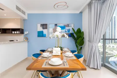 a dining room with blue walls and a wooden table and chairs at Ultimate Stay / 7 people / Spacious / Dubai Creek with Marina Views in Dubai