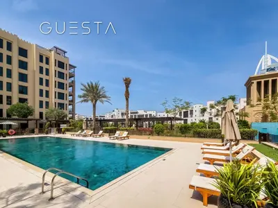 a swimming pool with lounge chairs and a hotel at Lamtara 1 - Madinat Jumeirah Living, Jumeirah in Dubai