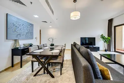a living room with a dining room table and chairs at Comfy 1BD family apartment in Shams JBR in Dubai
