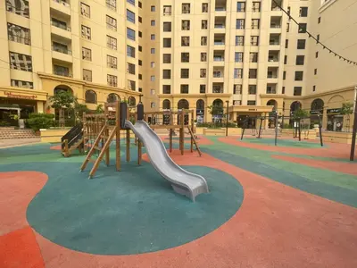 a playground with a slide in the middle of a building at Comfy 1BD family apartment in Shams JBR in Dubai