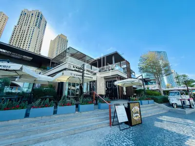 a building with plants and umbrellas in a city at Cozy 2 BD in Bahar JBR 24 floor in Dubai