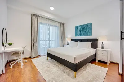 a bedroom with a bed and a desk and a computer at Cozy 2 BD in Bahar JBR 24 floor in Dubai