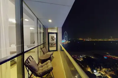 a balcony with two chairs and a view of the city at Palmar One Bedroom with Private Beach! in Dubai