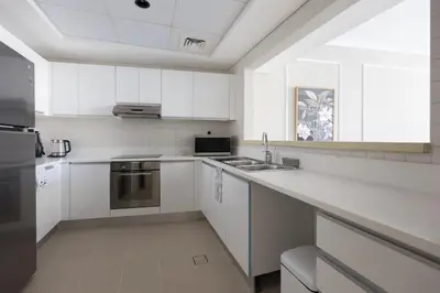 a white kitchen with a sink and a stove at Palmar One Bedroom with Private Beach! in Dubai