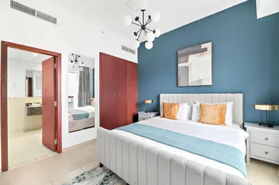 a bedroom with a large bed and a blue wall at Silkhaus just furnished 1BDR in JBR near the beach in Dubai