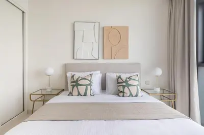 a bedroom with a bed with two tables and two lamps at Frank Porter - Beach Vista Tower 2 in Dubai