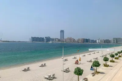 a beach with chaise lounges and the ocean at Frank Porter - Beach Vista Tower 2 in Dubai