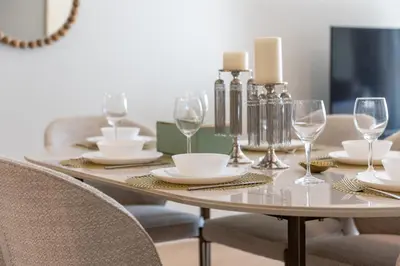 a dining room table with plates and glasses on it at Ultra Luxury Palm - Free 5-star Beach Resorts Access in Dubai