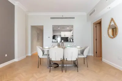 a dining room with a table and white chairs at Ultra Luxury Palm - Free 5-star Beach Resorts Access in Dubai