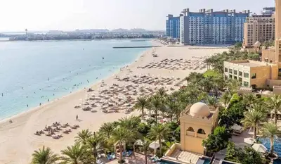 a view of a beach with umbrellas and the ocean at Ultra Luxury Palm - Free 5-star Beach Resorts Access in Dubai