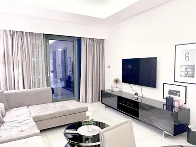 a living room with a couch and a flat screen tv at Cosmos Living 1 Bedroom Paramount Hotels in Dubai