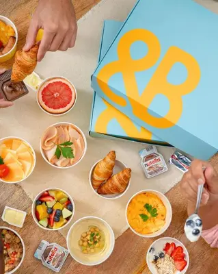 a table topped with bowls of food and a sign at Cosmos Living 1 Bedroom Paramount Hotels in Dubai