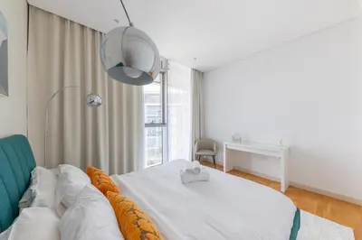 a bedroom with a bed and a desk and a window at Welcome Home - Bluewaters brand new 2-bedroom in Dubai