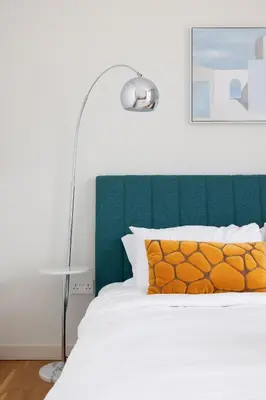 a bedroom with a bed with a green headboard at Welcome Home - Bluewaters brand new 2-bedroom in Dubai
