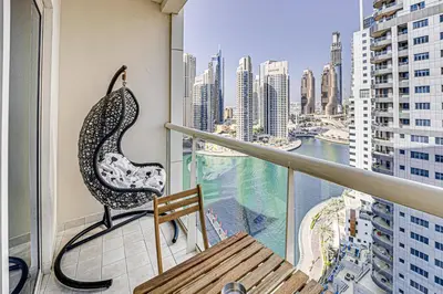a balcony with a bench and a view of a city at Canal View apartment in Marina in Dubai
