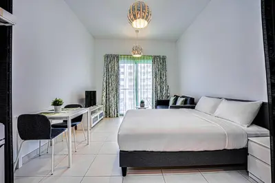 a bedroom with a large bed and a table and chairs at Canal View apartment in Marina in Dubai