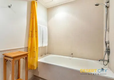 a bath tub with a yellow shower curtain in a bathroom at 2 Bed Room in Attessa Tower, Dubai Marina by Desert City Stays in Dubai