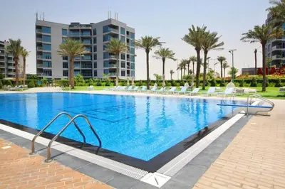 a large swimming pool with white chairs and palm trees at a chilled place in Dubai