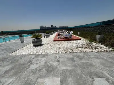 a patio with a table and chairs next to a pool at O2R26- Elegant Studio in O2 Residential Tower in Dubai