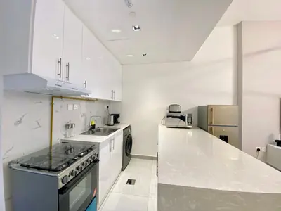a kitchen with white cabinets and a counter top at O2R26- Elegant Studio in O2 Residential Tower in Dubai
