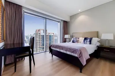 a bedroom with a bed and a desk and a window at 5-Star Address Dubai Marina Mall Stunning Marina Views 3-Bedroom in Dubai