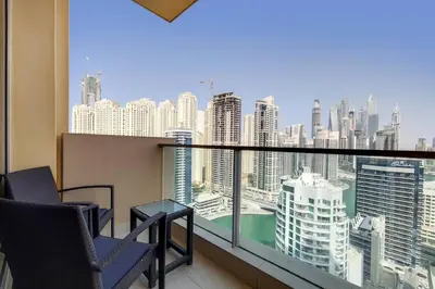 a balcony with chairs and a view of a city at 5-Star Address Dubai Marina Mall Stunning Marina Views 3-Bedroom in Dubai