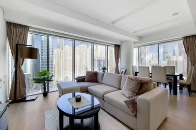 a living room with a couch and a large window at 5-Star Address Dubai Marina Mall Stunning Marina Views 3-Bedroom in Dubai