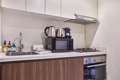 a kitchen with a microwave and a sink at Elegant 1BR in Vera Minutes from Dubai Mall in Dubai