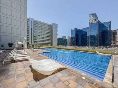 a large swimming pool on a building with buildings at Elegant 1BR in Vera Minutes from Dubai Mall in Dubai
