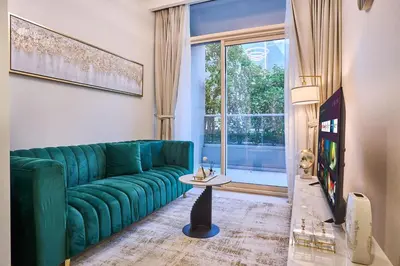 a living room with a green couch and a window at Elegant 1BR in Vera Minutes from Dubai Mall in Dubai