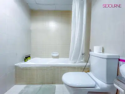 a bathroom with a toilet and a bath tub at LS10-Well Designed Studio In Lake Side Tower A in Dubai