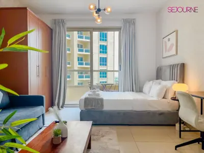 a bedroom with a bed and a large window at LS10-Well Designed Studio In Lake Side Tower A in Dubai